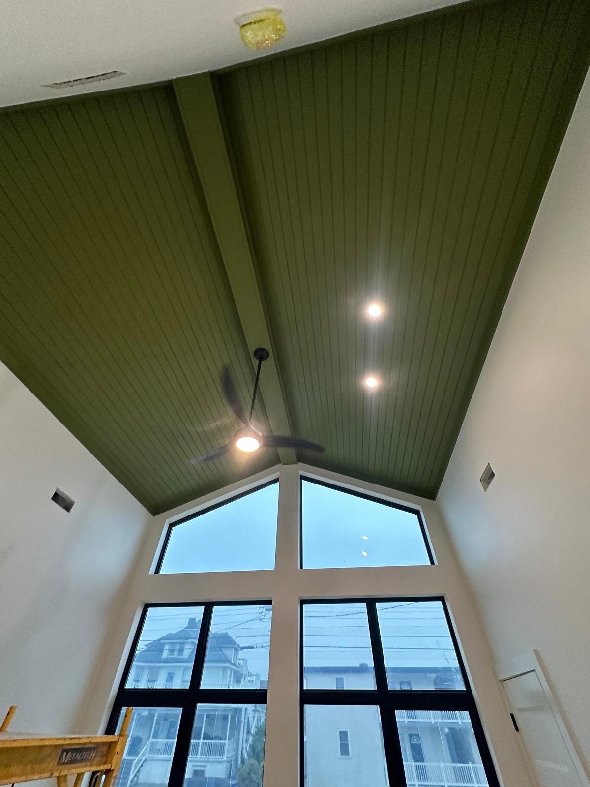 Completed green vaulted ceiling with beams and lighting